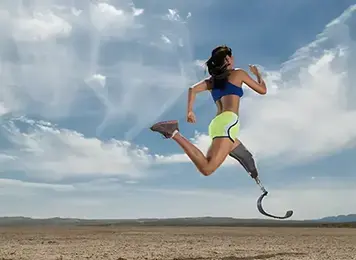 woman with prosthetic leg running across desert